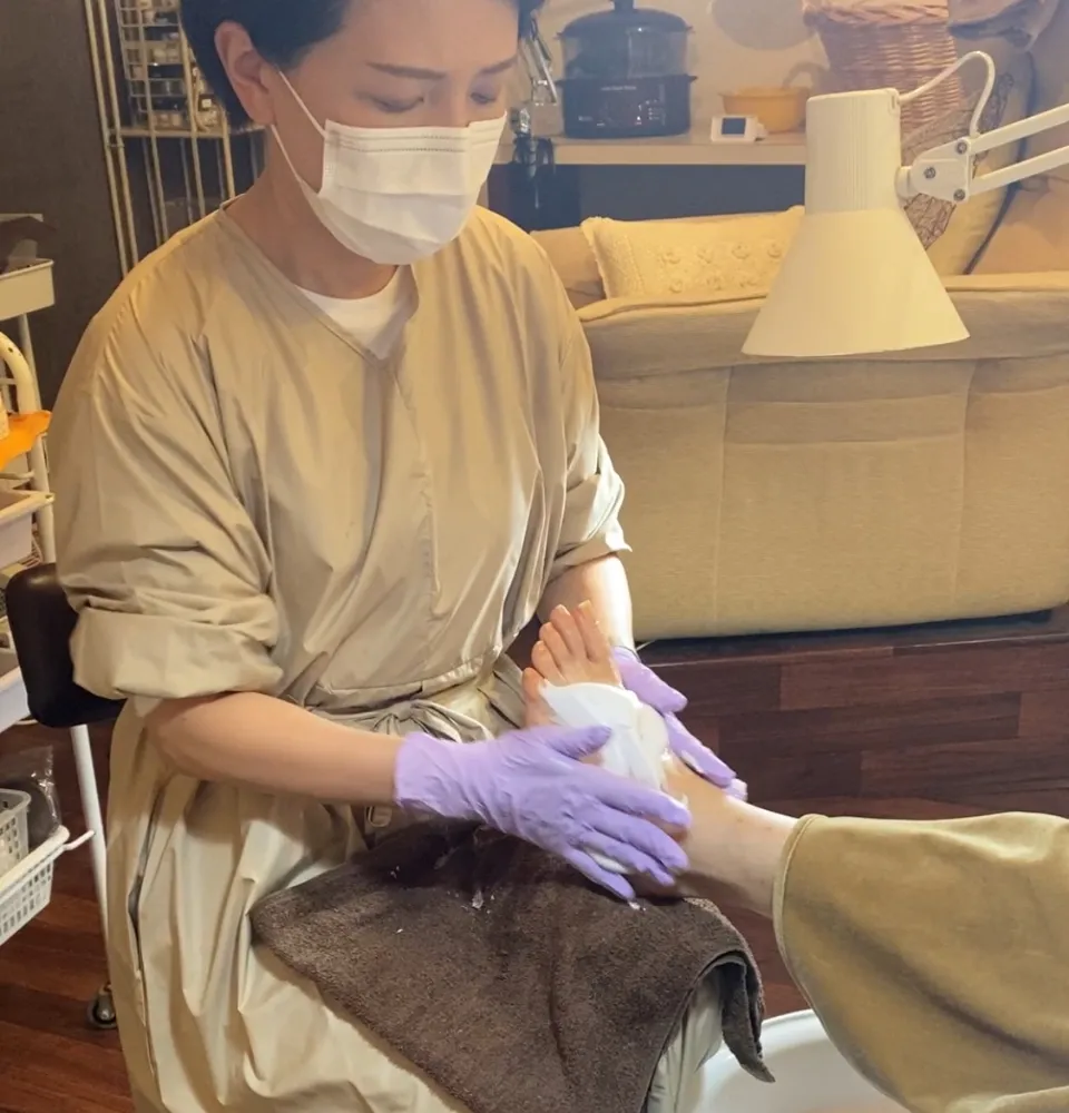 岡勢由紀子が足のケアをしている